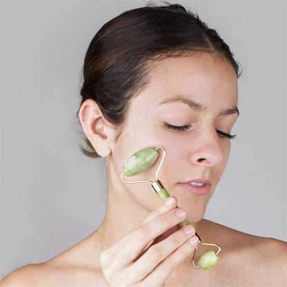 femme brune utilise gua sha rouleau