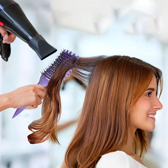 femme coiffe brosse à cheveux bouclés